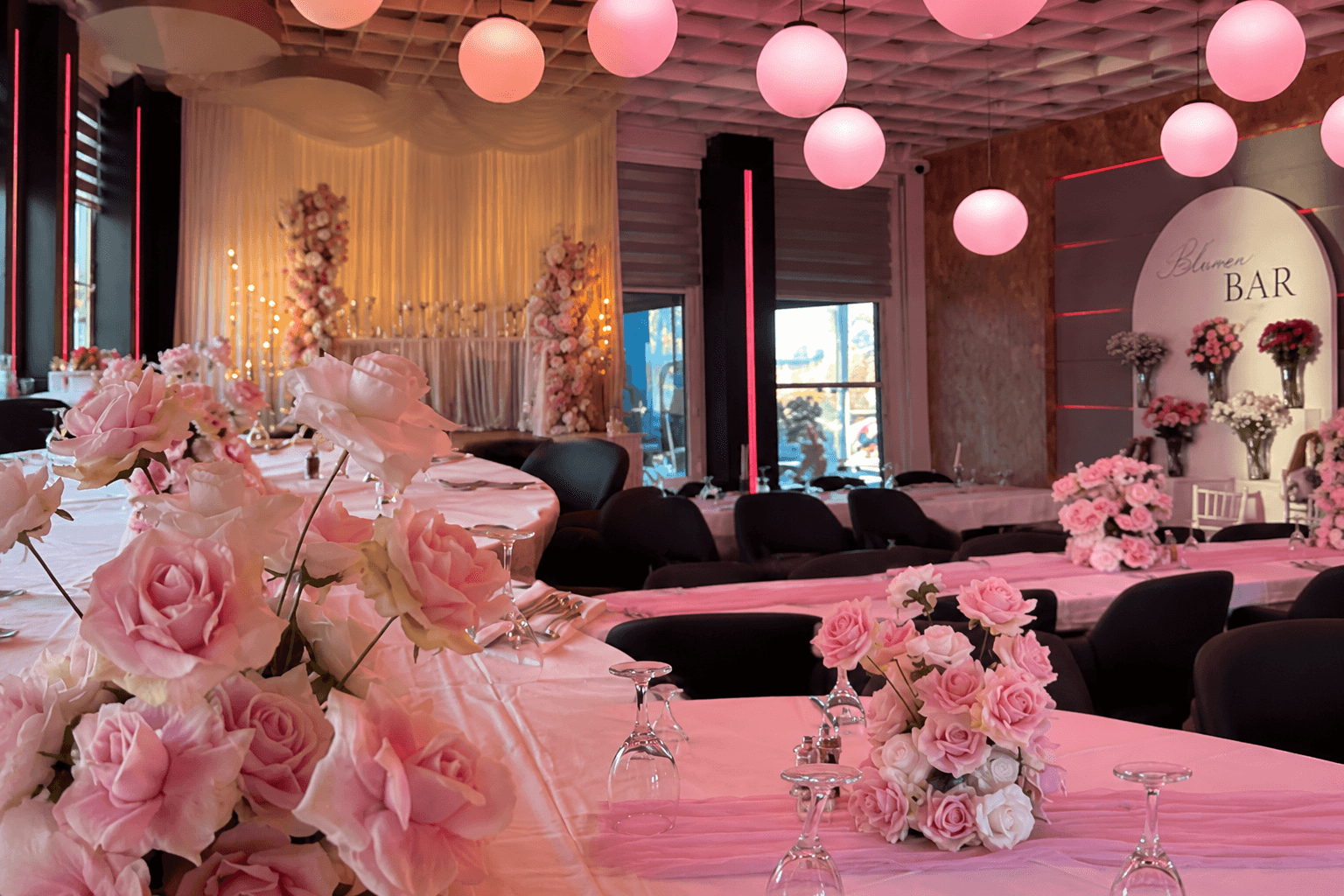 Festsaal mit rosa Rosen, Kugelleuchten und Blumenbar